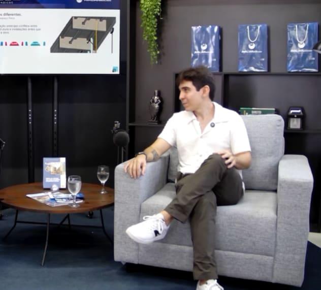 Filipe Marinho sentado em uma poltrona durante a palestra sobre BIM na Gestão Condominial, no SOS Síndicos